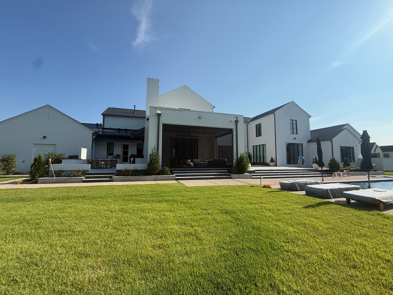 Rear elevation of an NWA home with spotless glass doors and pool